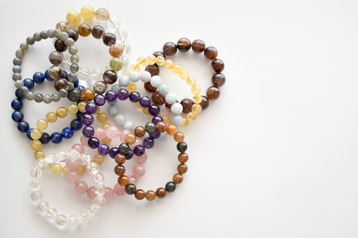Collection of crystal gemstones bracelets on the table.