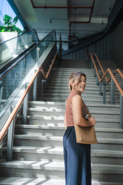 istock Elegance in Motion: Asian Beauty Ascends the Urban Staircase 2149226266