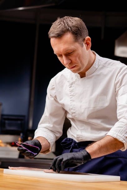 istock a chef in a professional kitchen in a white uniform takes out bones from fish with tweezers 2149226812