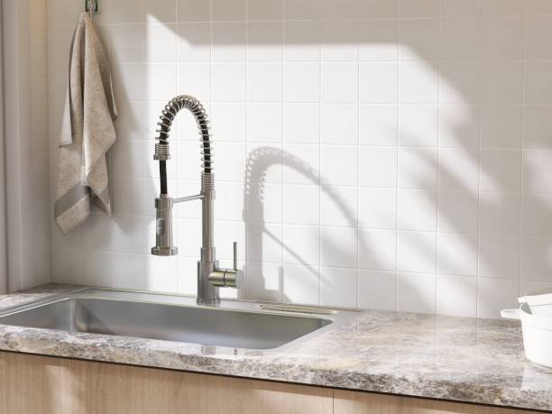 istock Marble kitchen table counter countertop, stainless sink, pull out faucet in sunlight on square white tile wall 2149227611