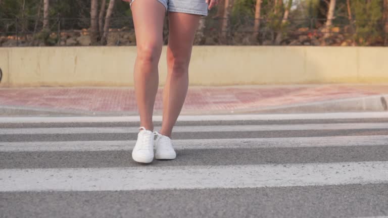 Close-up, a woman crossing the road at a pedestrian crossing