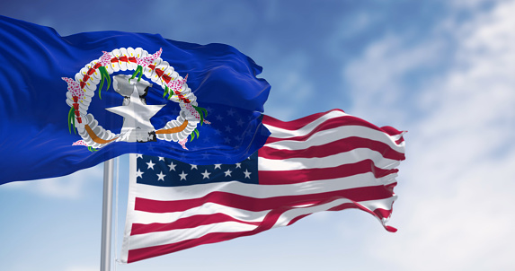 Flags of the Northern Mariana Islands and the United States of America waving on a clear day. Unincorporated territory of the United States 3d illustration render. Rippling fabric