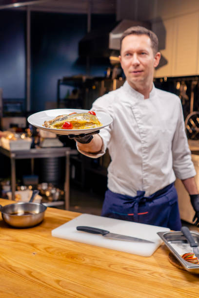 istock the chef demonstrates a ready-made fish dish at arm's length in professional kitchen 2149230472