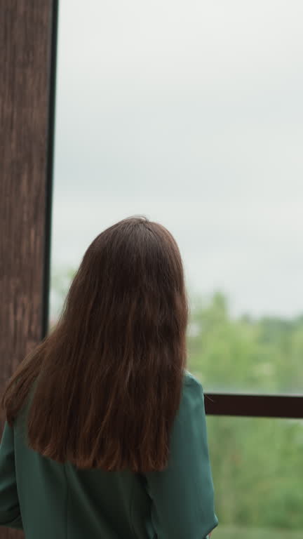 Woman in charge stares out office window