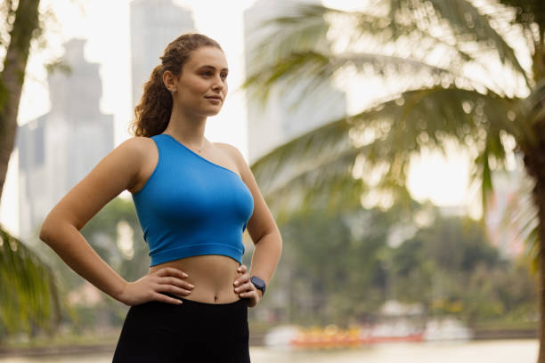 istock Smiling sportswoman day dreaming on a break in the park. 2149231579