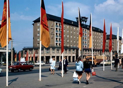 Residential houses and shops in Wilsdruffer Strasse in Dresden with flags of the GDR on the side of the road - German Democratic Republic.