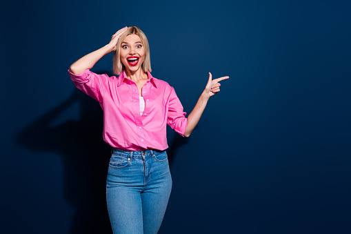 Portrait of eccentric woman wear stylish shirt indicating at unbelievable discount empty space isolated on dark blue color background.
