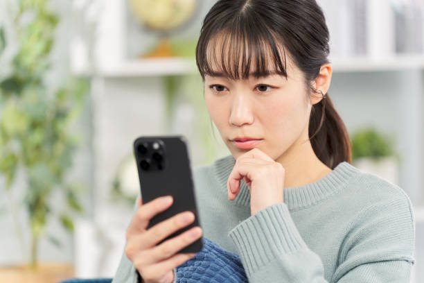 istock A woman looking at her smartphone with a serious expression 2149233333