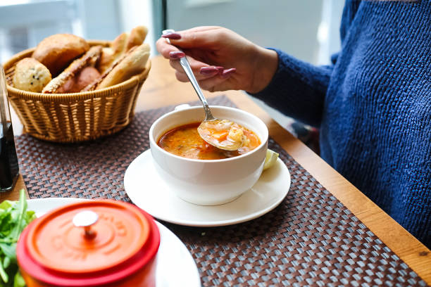 istock Woman Eating Bowl of Soup at Table 2149233379