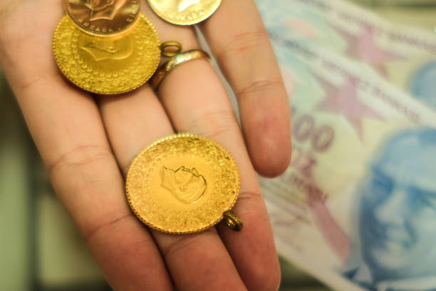 istock Woman's hand holding Turkish gold coin and Turkish lira 2149233403