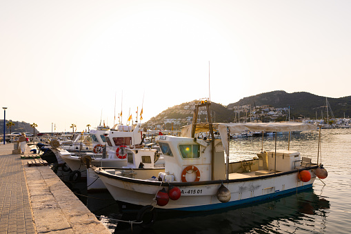 Puerto Andratx, Spain -April 14, 2024:  Small fishing boats in the harbor of Andratx in the late evening sun. The harbor in Puerto Andratx, Mallorca, is renowned for its affluent international visitors, whether tourists or residents, especially during sunset and for its pub nightlife.