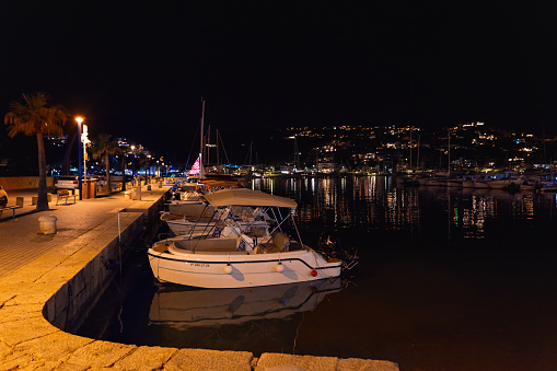 Puerto Andratx, Spain -April 14, 2024: View at the Puerto Andratx harbor at a boat dock at the night time. The harbor in Puerto Andratx, Mallorca, is renowned for its affluent international visitors, whether tourists or residents, especially during sunset and for its pub nightlife.