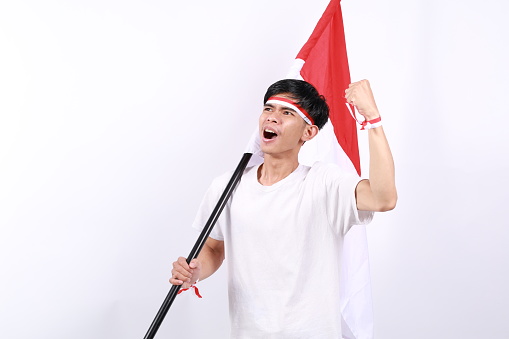 Indonesian youth full of enthusiasm carrying the flag while clenching his fists