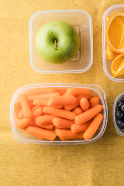 istock Lunch box with healthy snacks. Plastic container with fruits and vegetables closeup. 2149238442