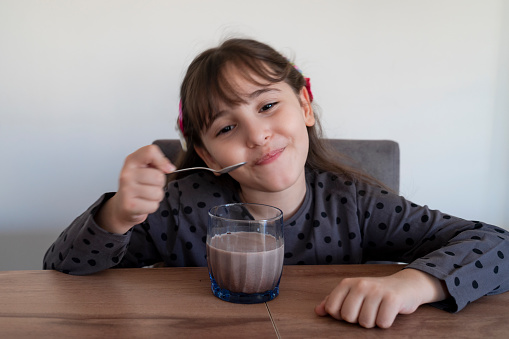 Little girl getting ready a glass of chocolate milk