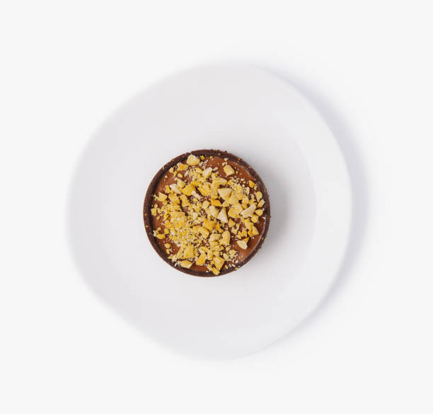 istock Delicious chocolate tart with nuts on white plate 2149239324
