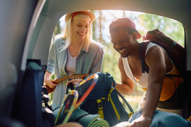 istock Happy couple unpacking their belongings from camping van trunk. 2149239903