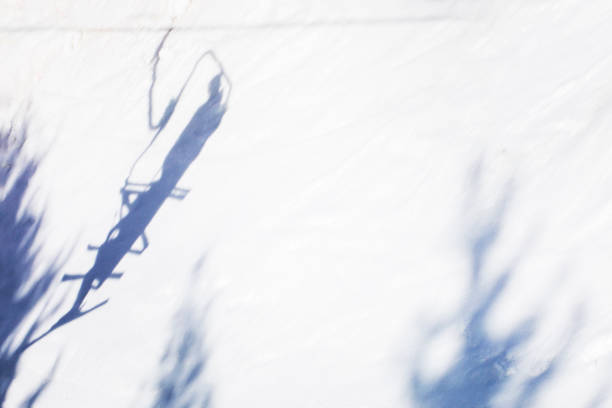 shadows from a ski lift on a snowy slope