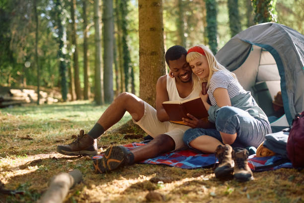 istock Happy couple reading book while camping in nature. 2149240079
