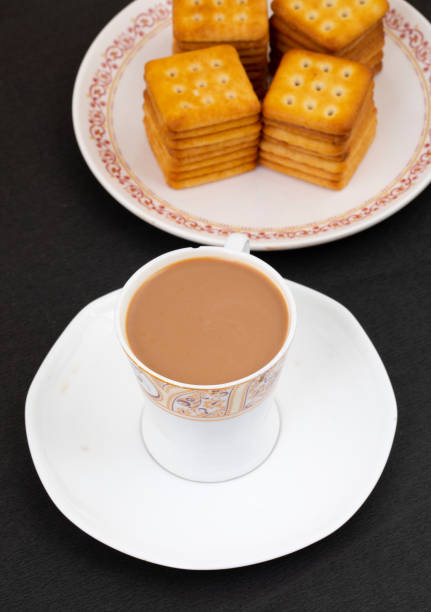 Indian Masala Chai or Morning Tea Served With Toast on Black Background