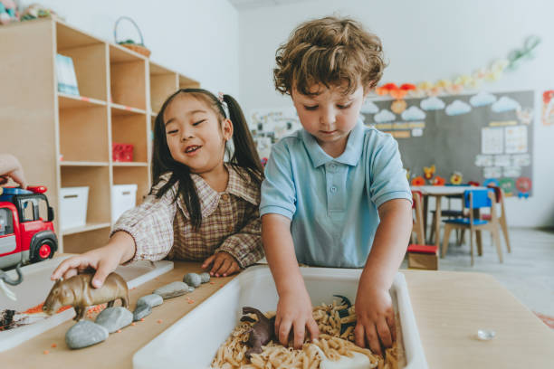 Children playing with toy figures in bulk cereals and pasta in kindergarten