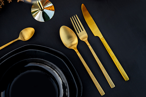 Elegance table setting in black and gold color. Close up, flat lay. Copy space
