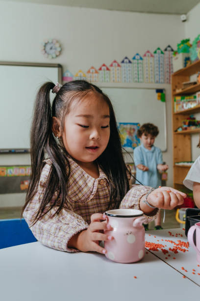 istock Little girl playing with cereal as a tactile material in kindergarten 2149241261