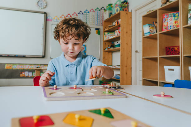 Boy playing with educational wooden toys in a kindergarten