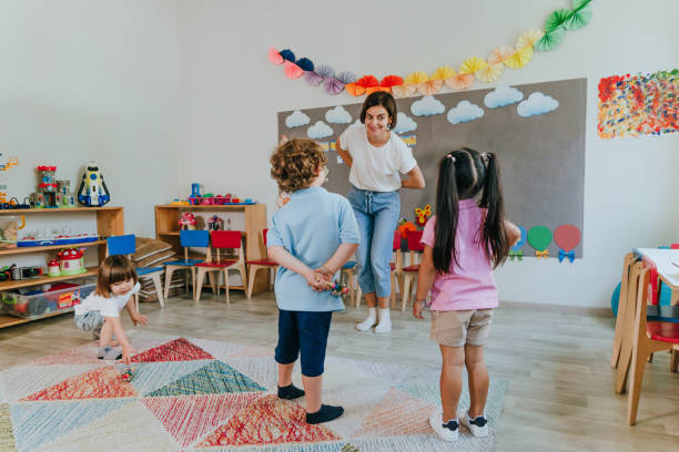 istock Young female teacher playing with children 2149241412