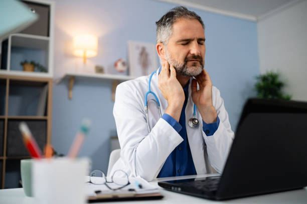 istock Male doctor experiencing neck ache, while working on laptop at the ordination 2149242163