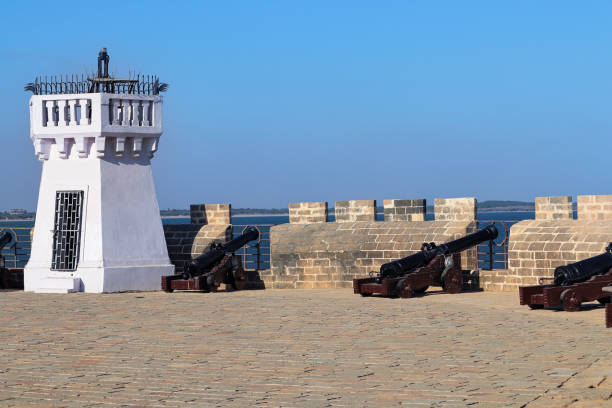 istock vintage diu fort in gujarat. The old whitewashed Couraca lighthouse inside the ancient, Portuguese built fort in the island of Diu 2149243288