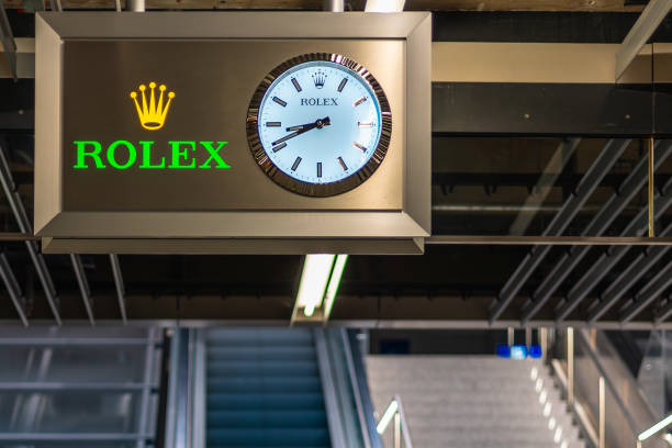 Frankfurt International Airport, Germany - February 19, 2024: a clock with a Rolex advertisement hanging in the airport terminal