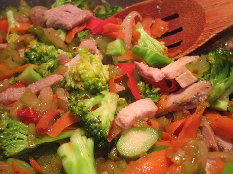 close-up of pork and mixed vegetables cooking in a wok