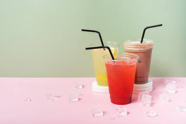 istock Three takeaway glasses of summer drinks with ice. Lemonade on coloured background 2149246086