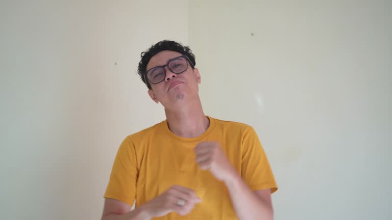 Young Indonesian curly man wear yellow t-shirt with sleepy gesture.