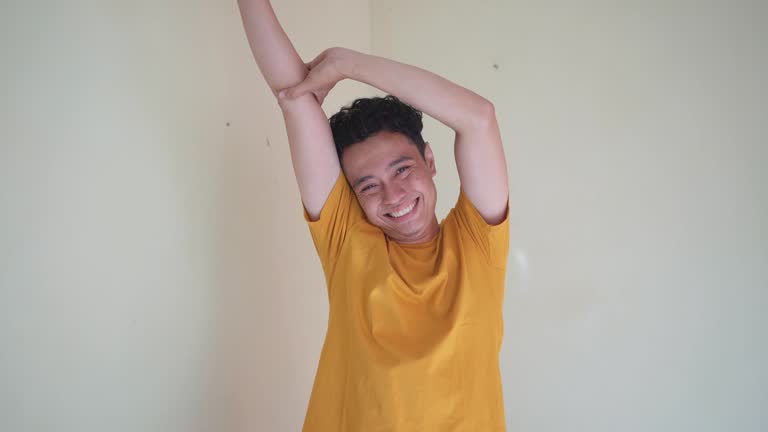 Young Indonesian curly man wear yellow t-shirt with sleepy gesture.