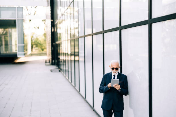 istock Senior businessman using digital tablet outdoors 2149250545
