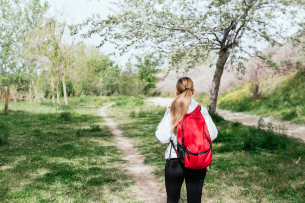 Woman walking along natural path in the countryside, unrecognizable