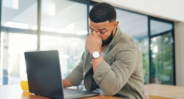 istock Remote work from home, man and laptop with stress, headache and tired with a deadline or anxiety. Apartment, freelancer or entrepreneur with computer, migraine or burnout with startup debt or fatigue 2149251056