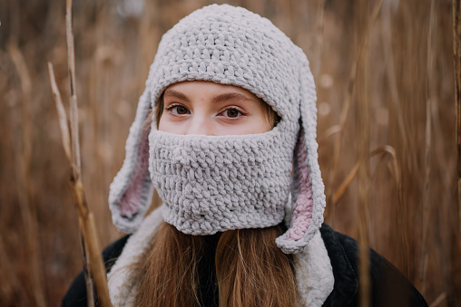 Portrait of young woman in crocheted hat in meadow