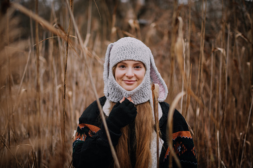 Portrait of young woman in crocheted hat in meadow
