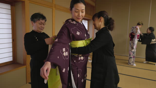 Female tourists getting kimono dressed in Japanese tatami room - part 1 of 2