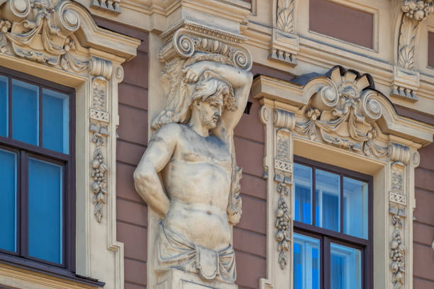 Atlantean holding an architectural element on the building facade: sculpture, bas-relief.
