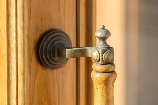 Retro-style door handle on a wooden surface: interior detail, design.