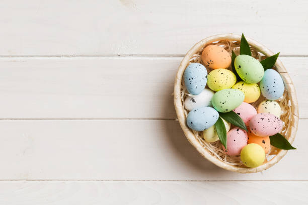 istock Colorful Easter eggs in wicker basket against colored background, closeup. top view with copy space 2149257082