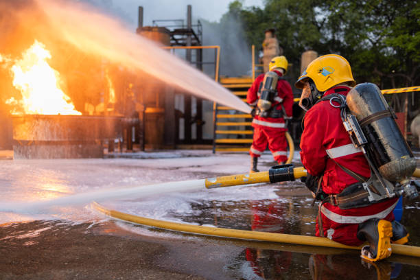 istock Firefighters Controlling Flame with Foam Spray at Dusk 2149259860