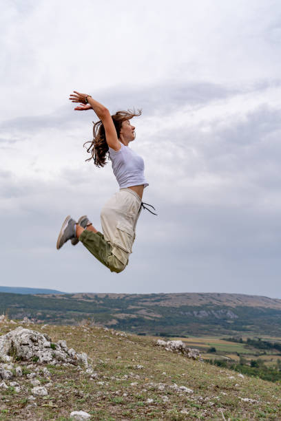 istock Young Woman Jumping On The Rocky Mountain 2149262127