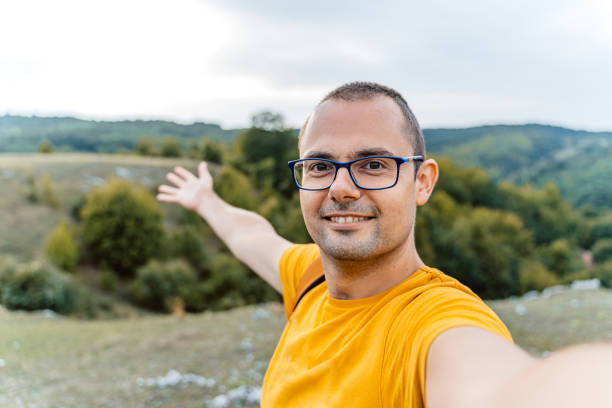 Young man taking selfies on the rocky mountain in Serbia.