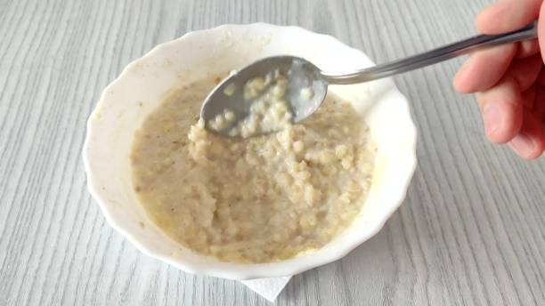 istock Unrecognizable person stirs oatmeal with millet with a spoon 2149262923