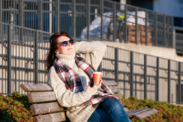 istock Relaxed woman  sitting on the bench in  city . 2149263165